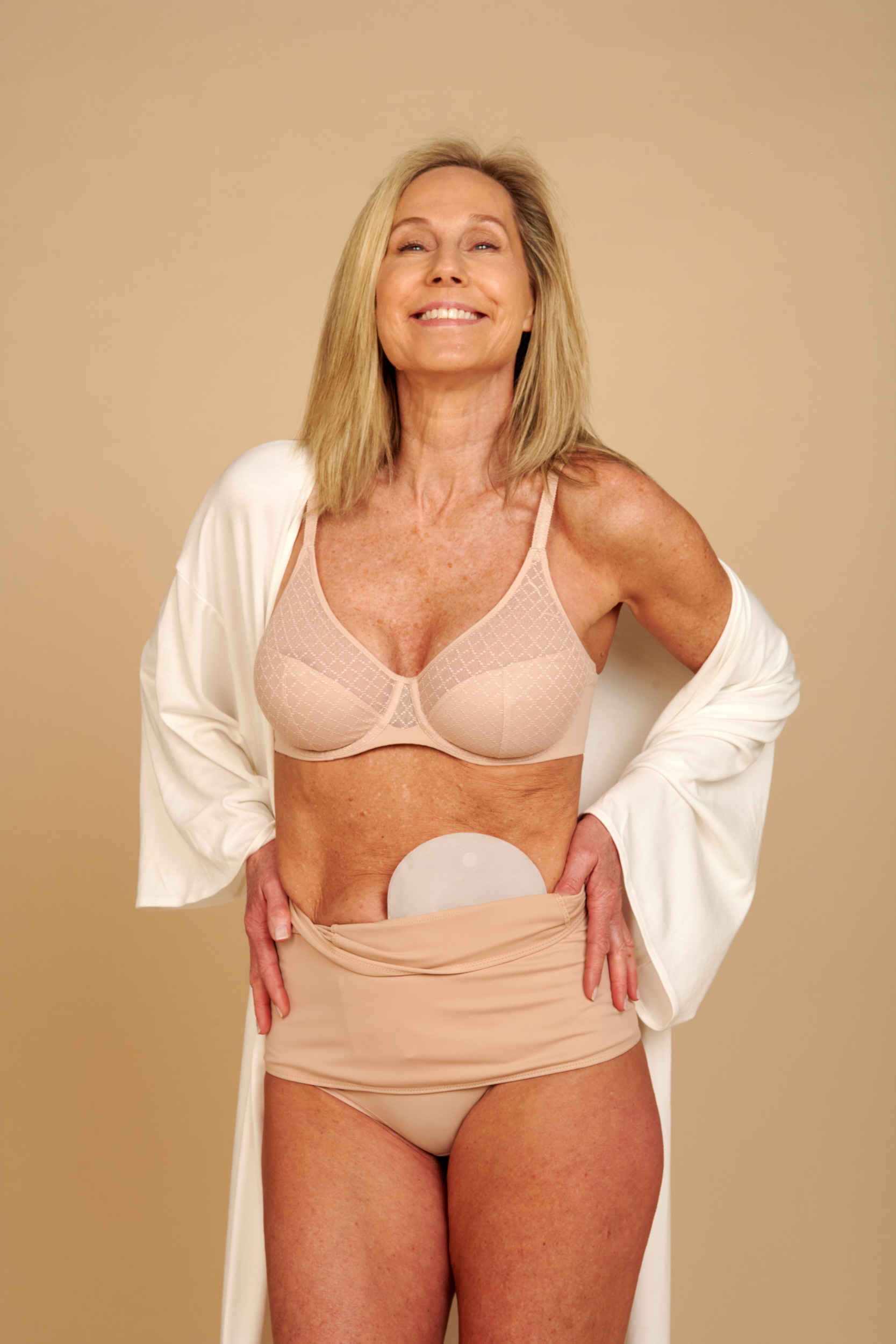 Woman pulling SIIL ostomy wrap up over her hips