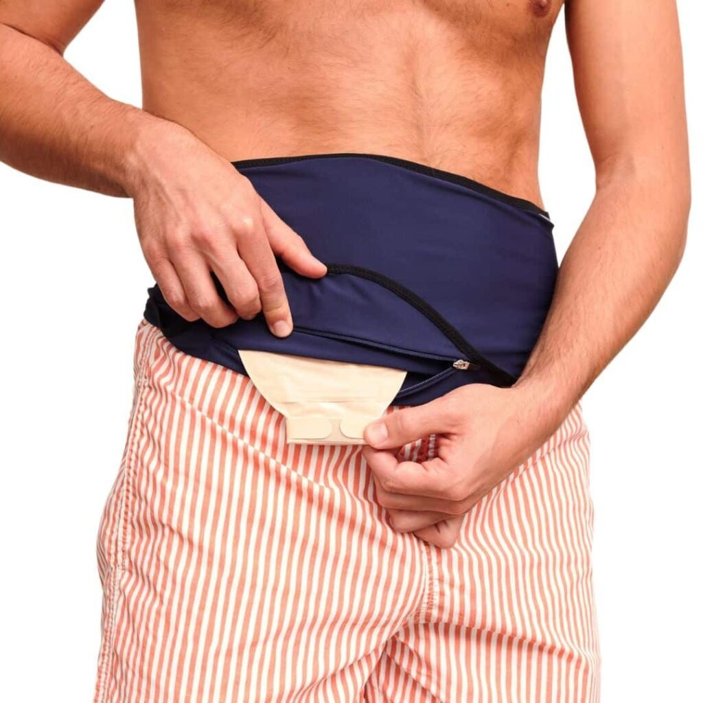 navy ostomy bag cover belt zip pocket hands opening the zip pocket of a navy ostomy belt, an ostomy bag cover, over the pouch