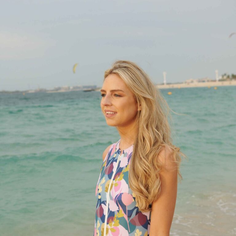 Woman on the beach in a floral SIIL ostomy swimsuit