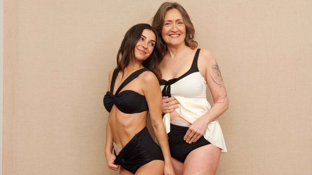Swimming with an ileostomy: two women laughing in black high-waisted SIIL ostomy swimwear
