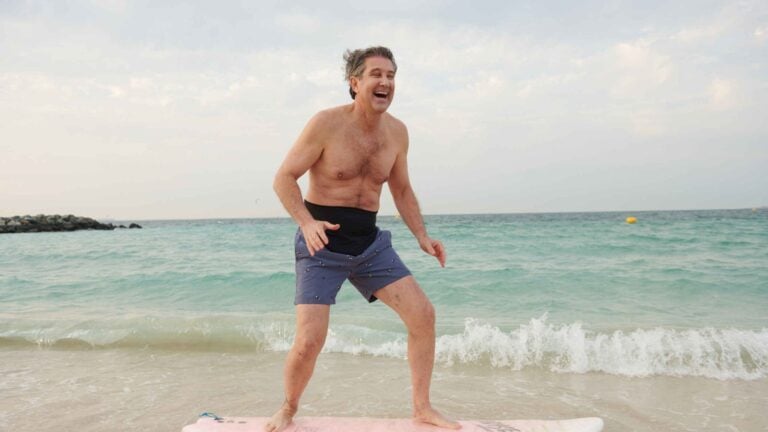 Man on the beach wearing the SIIL stoma belt over his bag