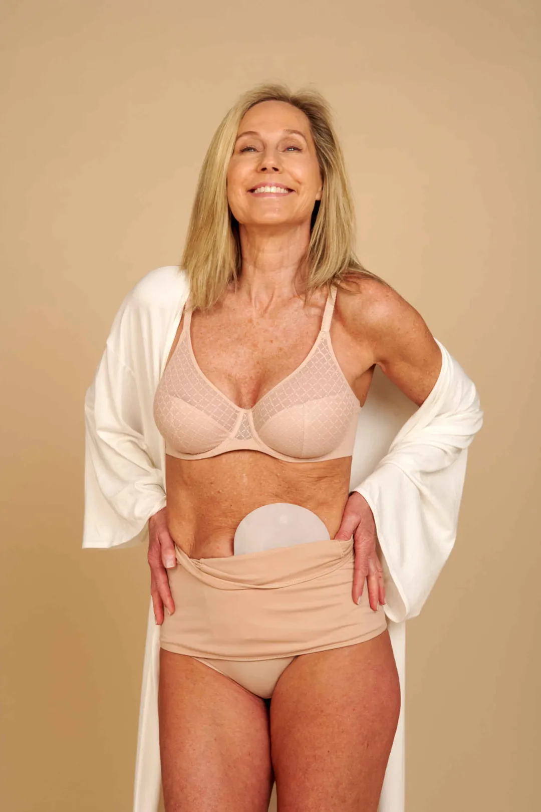 Woman pulling SIIL ostomy wrap up over her hips