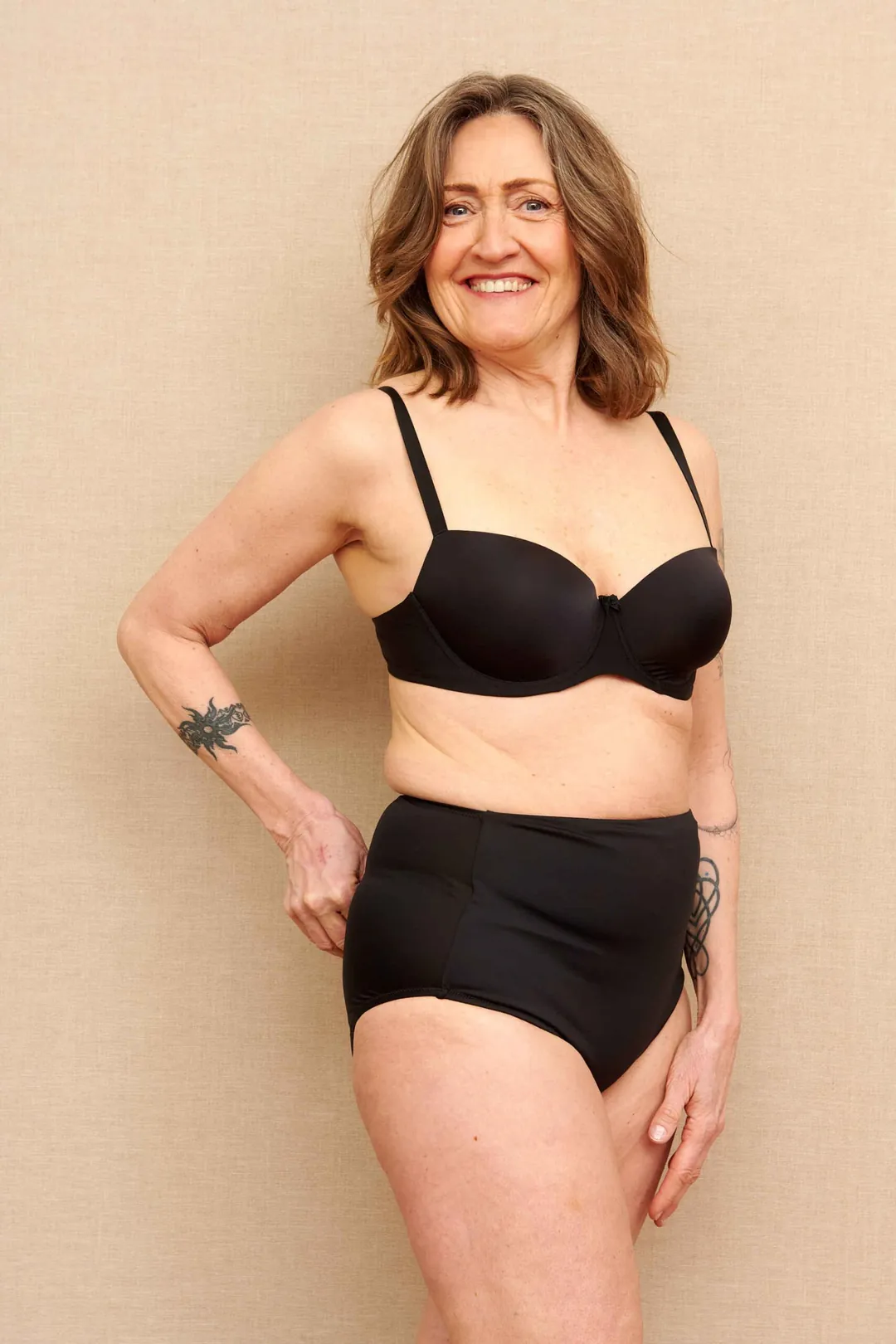 Woman wearing black SIIL Classic ostomy panties at her natural waist, ready to get dressed